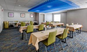Austinburg阿什塔比拉日内瓦智选假日酒店及套房的一间设有桌椅的用餐室和蓝色的天花板