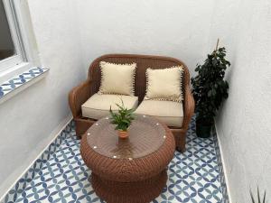 阿尔齐拉Alzira bonita Apartamento B con patio, la Casella的柳条椅,桌子,椅子,桌子,四面八方