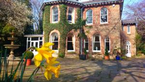 曼斯菲尔德Ravenscroft B&B的前面有黄色花的砖砌建筑