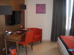 菲乌米奇诺台伯酒店的客房设有书桌、椅子和床。