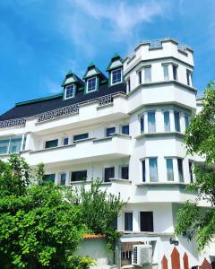 普罗夫迪夫HOTEL THE WHITE HOUSE Plovdiv的白色的建筑,有黑色的屋顶