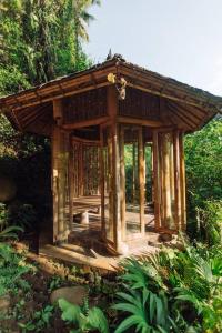 BringkitTemple House 3bds Eco Bamboo House Pool River View的森林中间的小木结构