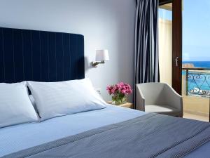 干尼亚Porto Veneziano Hotel的卧室配有床、椅子和窗户。