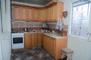 塞凡Norik's Guest House的一个带木制橱柜和窗户的小厨房