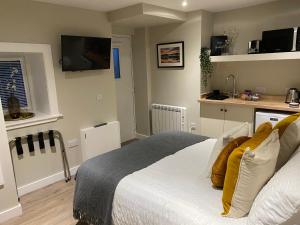 奥本Greenbank, Lower Greenbank Guest Suite的一间卧室配有白色床和黄色枕头
