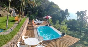 弗洛里亚诺波利斯Suite com piscina的一个带桌椅和遮阳伞的游泳池
