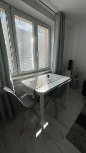 特尔纳瓦Apartment Hospodárska的窗户间里的一张桌子和一把椅子