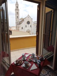 Palo del ColleB&B Il Principe的一张桌子,上面有杯子和碟子,享有教堂的景色