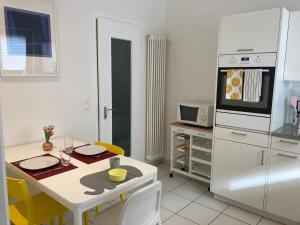 洛迦诺Appartamento con giardino al Melograno的厨房配有桌子和白色冰箱。