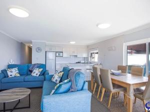 纳鲁马Sapphire Waters Unit 3的客厅配有蓝色的沙发和桌子