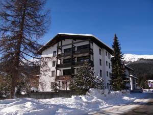 伦策海德Apartment Tgesa La Roiva mit Hallenbad und Sauna的雪中一座白色的大建筑,有树木