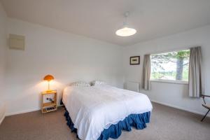 汉默温泉15 Bristol Street的白色的卧室设有床和窗户