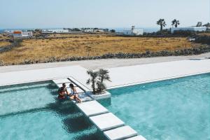 米克诺斯城Adama Mykonos Boutique Hotel的一组三人站在游泳池旁