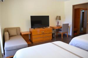 塞班塞班海滩酒店的酒店客房设有电视、床和书桌