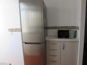 韦尔瓦Luz y Mar Huelva-Ático的厨房配有冰箱和微波炉