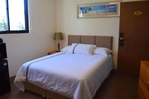 塞班塞班海滩酒店的卧室设有一张白色大床和一扇窗户。