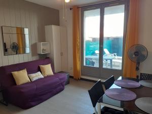 鲁西隆地区卡内Appartement Canet Sud Jardin et parking的客厅配有紫色沙发和桌子