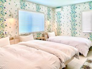 直岛町斯帕奇公寓的卧室内的两张床,配有花卉壁纸