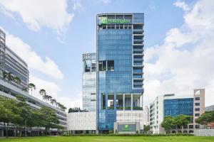 新加坡Holiday Inn Singapore Little India, an IHG Hotel的一座高大的玻璃建筑,上面有标志
