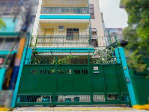 马尼拉OYO 840 Orangenest Apartelle的大楼前的绿色大门