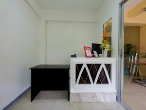 马尼拉OYO 840 Orangenest Apartelle的一间设有白色橱柜和黑桌的房间
