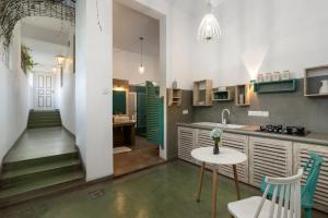 康提Ru Boutique的厨房配有绿色橱柜和桌椅