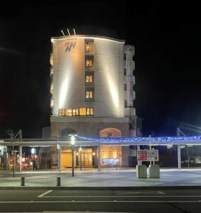 小松市Hyper Hotel Komatsu的前面有蓝色横梁的高楼