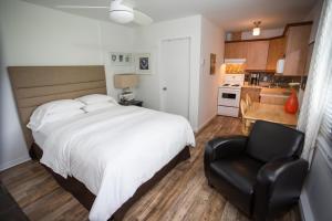 布罗蒙布罗蒙公寓式酒店的卧室配有白色的床和黑椅