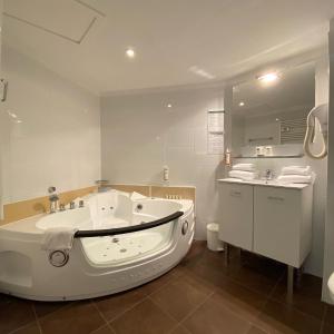 佩皮尼昂The Originals City, Hôtel Les Dômes, Perpignan Sud Saleilles的白色的浴室设有浴缸和水槽。