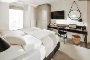 诺德奈Villa Breeksee的白色卧室配有书桌和床