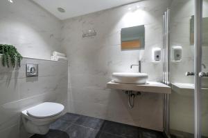 埃拉特Melio Hotel Eilat的白色的浴室设有卫生间和水槽。