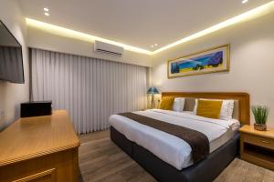 埃拉特Melio Hotel Eilat的配有一张床和一张书桌的酒店客房
