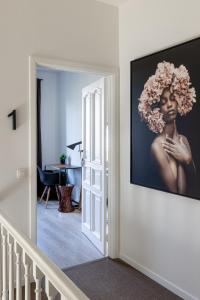 赫林贝亨B&B Josephine的墙上挂着一幅花朵的女人的照片的走廊