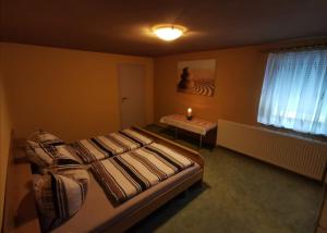 Am FrühlingsbergDuschkas Ferienwohnung的一间卧室配有一张床、一张桌子和一个窗户。