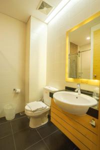GembongLife Hotel Stasiun Kota Surabaya的一间带卫生间、水槽和镜子的浴室