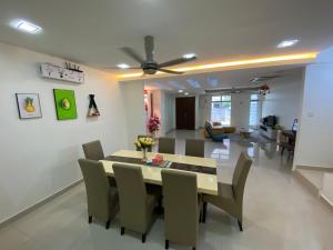 史里肯邦安Entire Residential Home•Jia Residences Bkt Serdang沙登温暖的家的用餐室以及带桌椅的起居室。