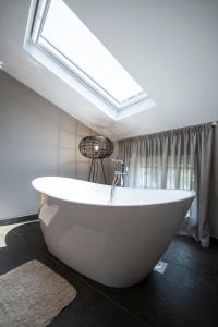 巴莱拉芙公寓式酒店的浴室配有白色浴缸,设有天窗