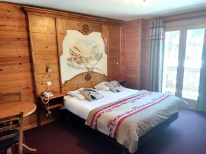 普拉洛尼昂拉瓦努瓦斯Epicéa Lodge Hôtel的一间卧室配有一张木墙床