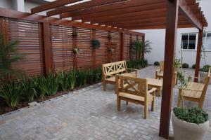 卡斯卡韦尔Hotel Plaza Cascavel的庭院设有2个长椅和木制凉亭。