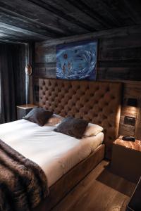 布勒伊-切尔维尼亚Art Hotel Grivola的一间卧室配有一张大床和大床头板
