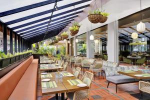巴加Radisson Resort Goa Baga的餐厅设有桌椅和窗户。