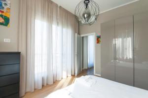 米兰YouHosty - Algardi 5的一间卧室配有一张床和一个吊灯
