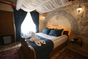 ÇadırAkritis suit Cappadocia的一间卧室设有一张大床和大窗户