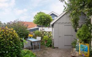 欣德洛彭Uit Alle Windstreken的一个带灰色棚子和桌子的花园