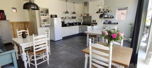 欣德洛彭Uit Alle Windstreken的厨房配有桌椅和冰箱。