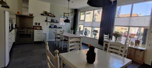 欣德洛彭Uit Alle Windstreken的厨房以及带桌椅的用餐室。