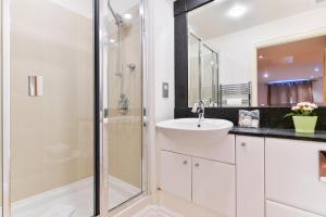 伦敦Paddington Gardens的白色的浴室设有水槽和淋浴。