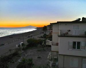 博瓦马里纳Villa Tripepi的从大楼欣赏日落海滩美景