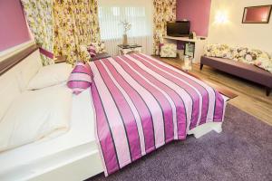 福森霍普芬斯酒店的一间卧室配有带条纹毯子的床