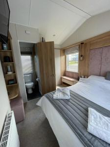 塞顿港Seton sands holiday park - Premium caravan - 2 bedroom sleeps 4的一间卧室设有一张大床和一个卫生间